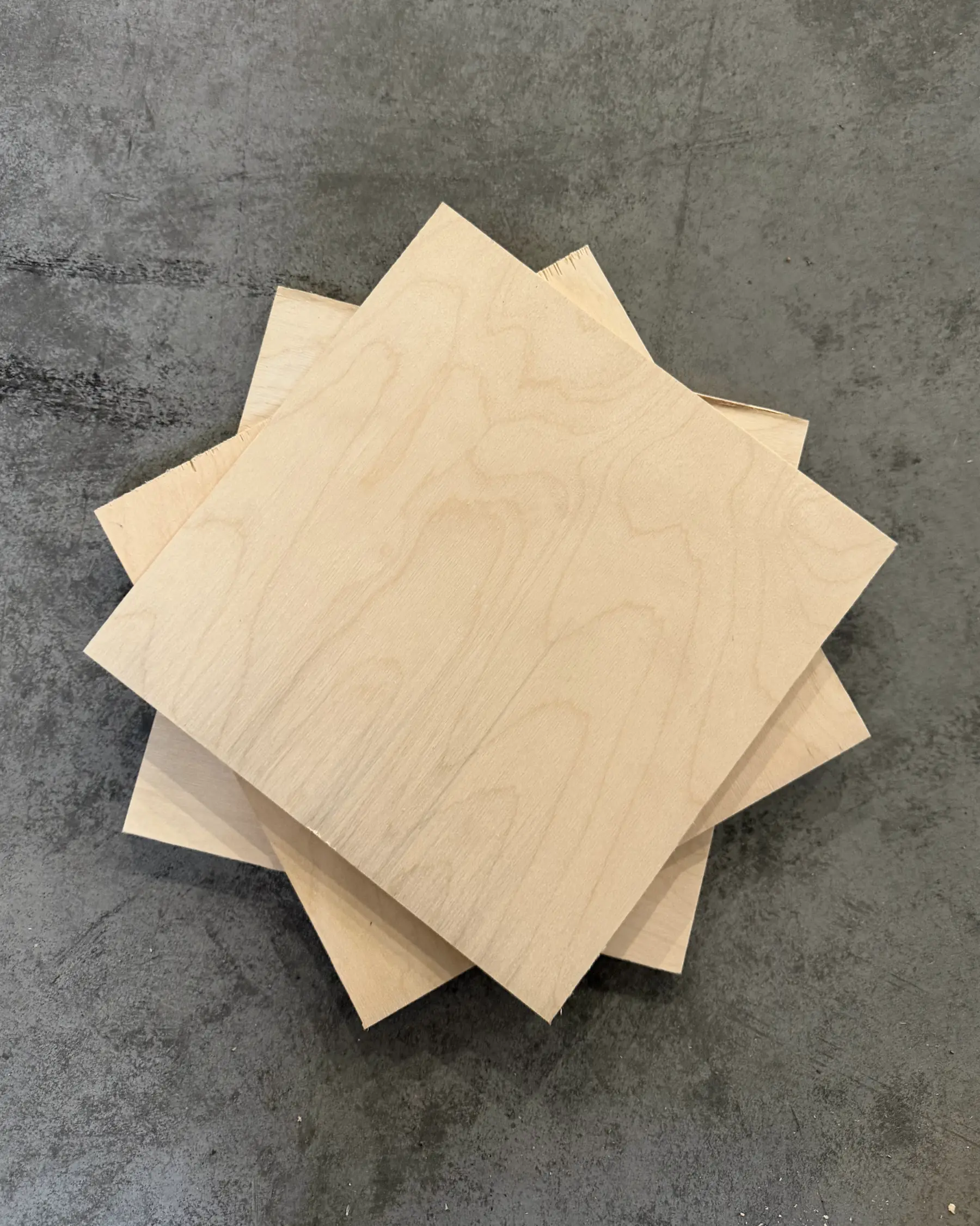 Birch plywood sheets stacked on a concrete floor