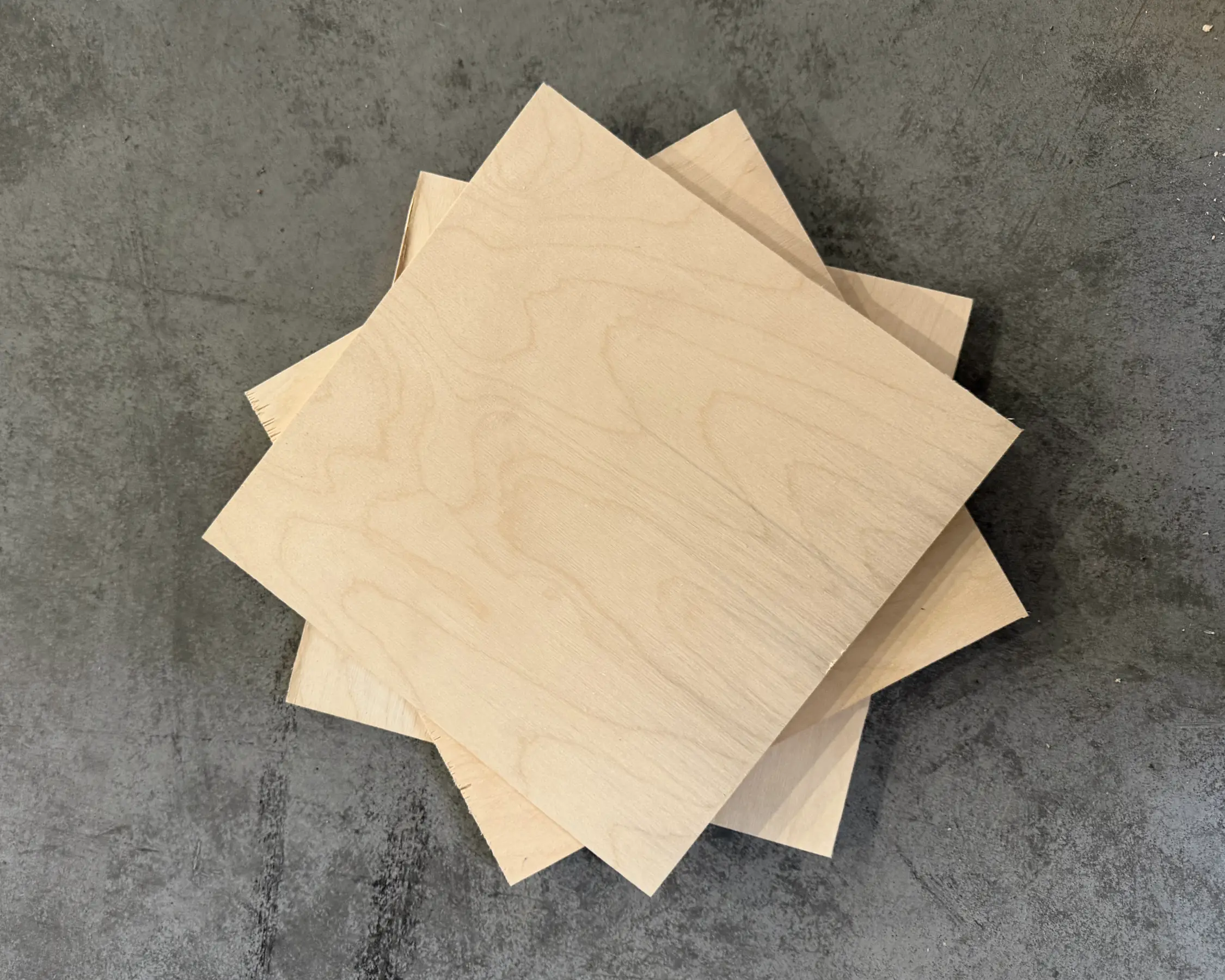 Birch plywood sheets stacked on a concrete floor