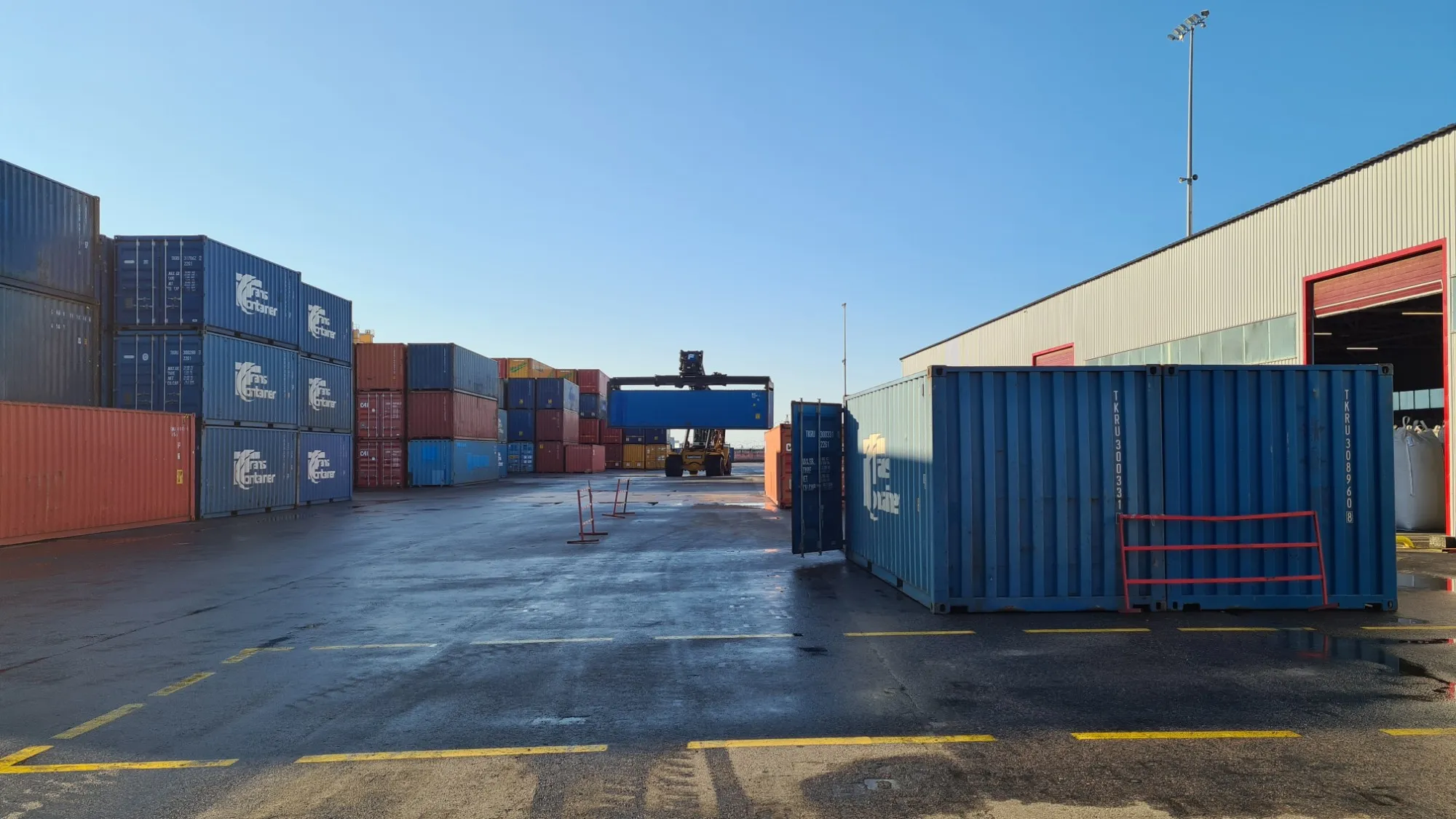 Container terminal with a reach stacker lifting a container